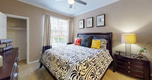Luxury apartments with spacious bedrooms, walk-in closets, and ceiling fans at Tuscany Apartments in Houston.