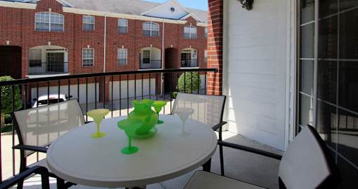 Luxury townhomes in a gated community with red brick exteriors and attached 2-car garages at Tuscany Villas in Houston.