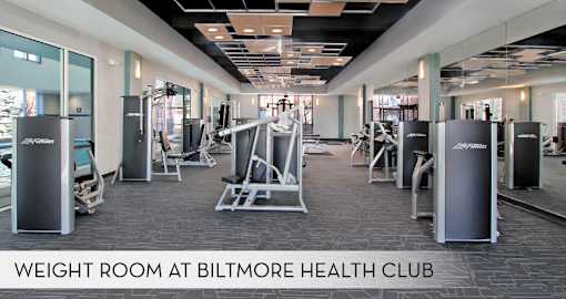 A gym with a variety of equipment including weight machines and free weights.