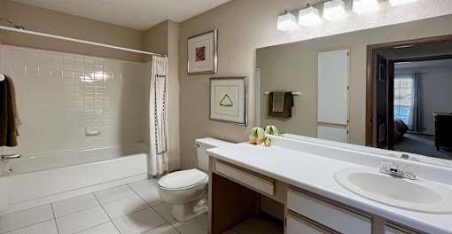 Spacious bathroom with tiled floor, tiled shower with bathtub, extra cabinet space and linen closet at Tanglewood Apartments in Lincoln Nebraska