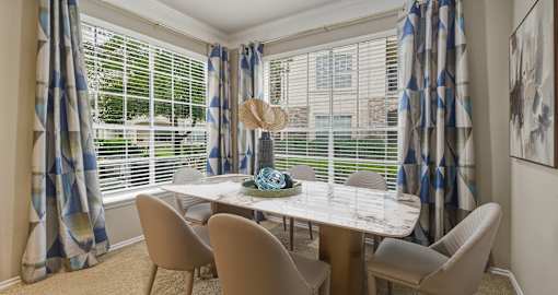 Spacious dining room with huge windows and lots of natural light at Village on the Parkway Apartments in Houston Texas