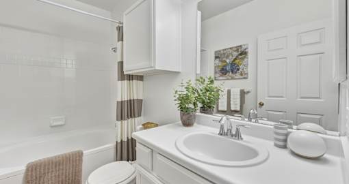 Spacious bright white bathroom with oversized garden tub, lots of cabinet space and built-in vanity at Village on the Parkway Apartments