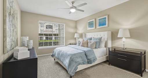 Spacious master bedroom with attached master bathroom, spacious walk-in closet and grey colored walls at Village on the Parkway Apartments in Houston, Texas