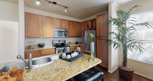 Luxury apartments with hardwood floors, granite countertops, side-by-side refrigerator, and stainless appliances at The Voss Apartments in Houston.
