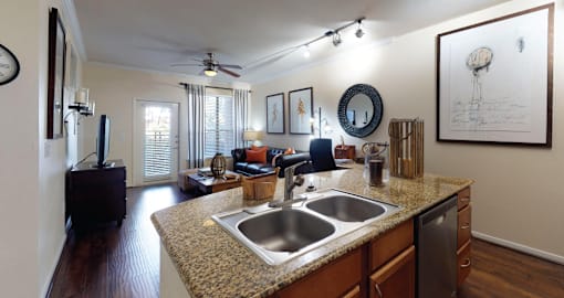 Luxury apartments in Houston with spacious open floor plan with granite countertops, kitchen island, stainless steel appliances, oversized windows, and hardwood floors.