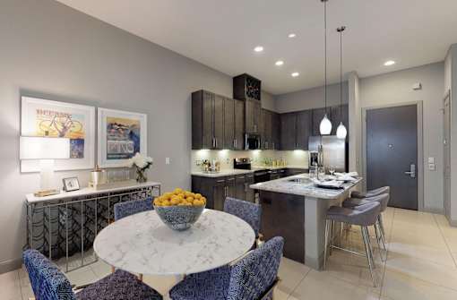 Luxury apartments with spacious kitchens with granite countertops, large granite slab island, built-in wine rack, and stainless appliances at Le Palais Apartments in Houston.