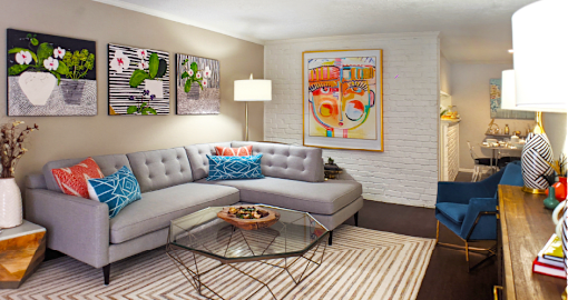Spacious one and two bedroom floor plans with white brick accent walls and wood plank floors at Waters of Winrock Apartments in Houston.