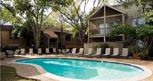 Gated apartments with 2 swimming pools, convenient bayou location, lush landscaping and scenic views at Woodlake Oaks Apartments in Houston.