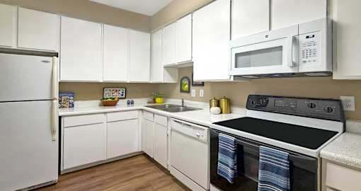 A kitchen with white cabinets and appliances.