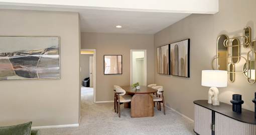 A living room with a painting on the wall and a green chair.