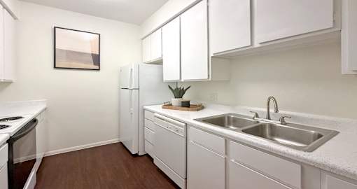 A kitchen with white cabinets and a white countertop.
