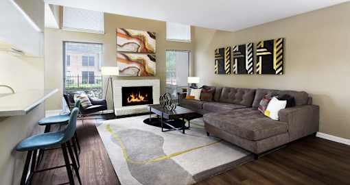 Spacious floor plan with wood-burning fireplace, breakfast bar, oversized windows and wood plank floors at Woodlake on the Bayou Apartments in Houston