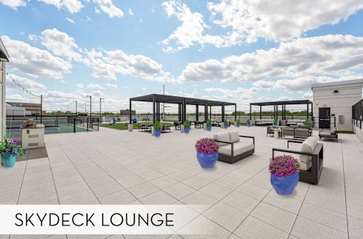 Luxury Skydeck lounge with tables and chairs, comfortable seating and pergola, rooftop sports courts, modern rooftop lounge space at Xenia Apartments in Golden Valley Minnesota