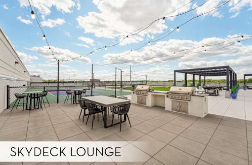 Luxury Skydeck lounge with tables and chairs, comfortable seating and pergola, grilling area, modern rooftop lounge space at Xenia Apartments in Golden Valley Minnesota