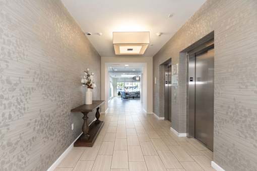 A hallway with a bench and a wallpapered wall.