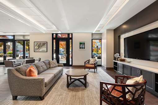 A living room with a grey couch and a brown chair.
