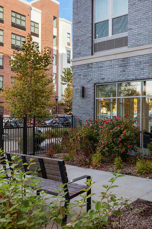 A bench is in the foreground of a brick building.