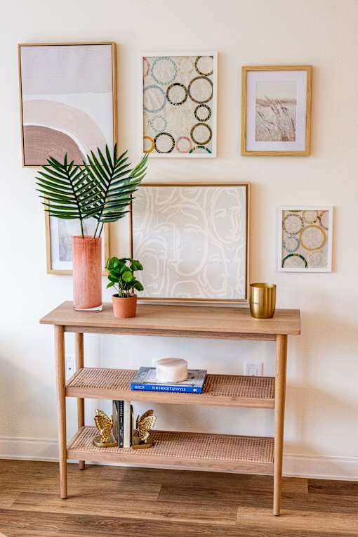 A wooden shelf with a plant and a vase on it.