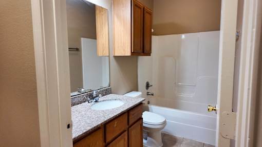 A bathroom with a white toilet and a white bathtub.