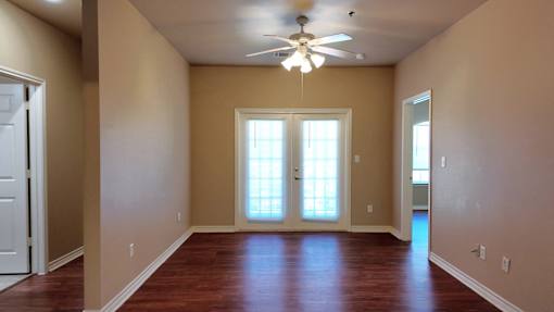 A room with a ceiling fan and a window.