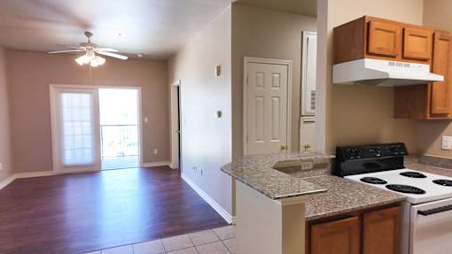 A kitchen with a stove top oven and a fan.