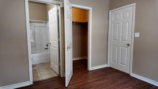 A room with a white door and a white bathtub.