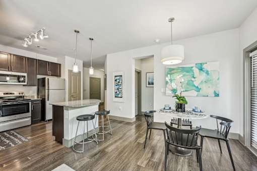 A modern kitchen with a dining table and chairs.