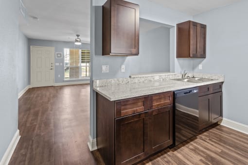 an empty kitchen with wooden floors and a counter top with a sink