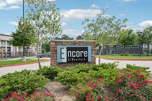 The entrance sign of Encore at Westfork with lovely apartment building in the background.