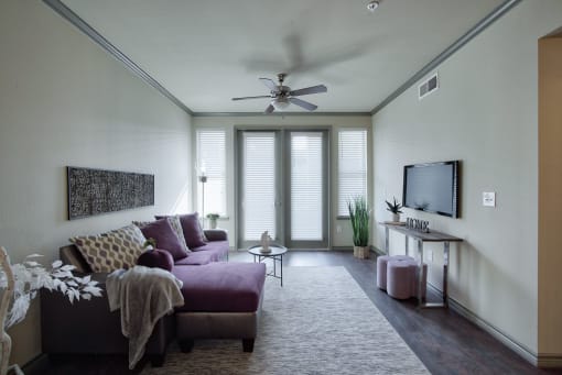 a living room with white walls and a purple couch