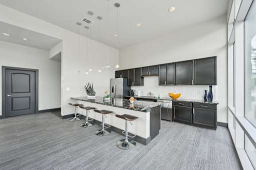 A modern kitchen with a bar area and a grey floor.