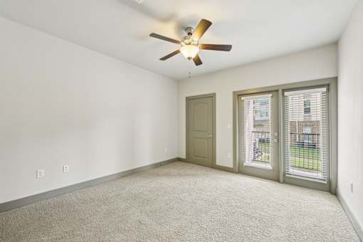 A room with a ceiling fan and a carpeted floor.