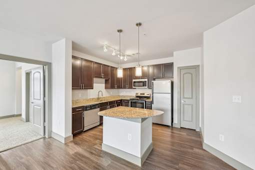 A kitchen with a white island and wooden floors.