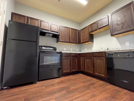 a kitchen with black appliances and wooden cabinets