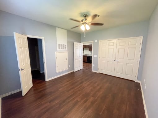 an empty living room with a ceiling fan