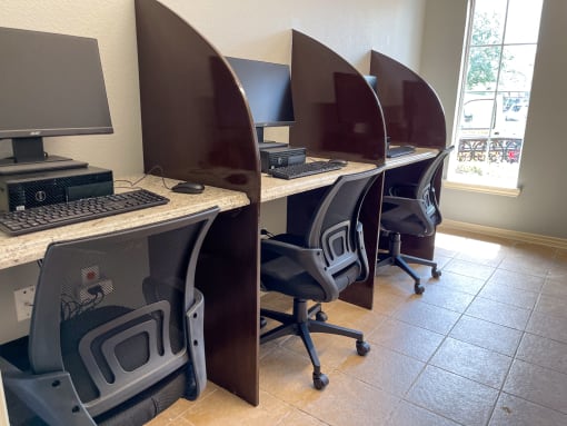 a row of computer desks in a room with a window