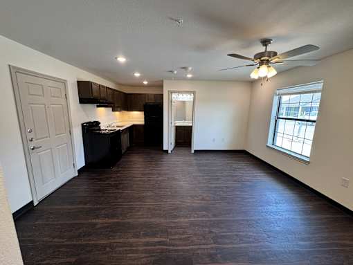 A spacious room with a kitchen area and a window.