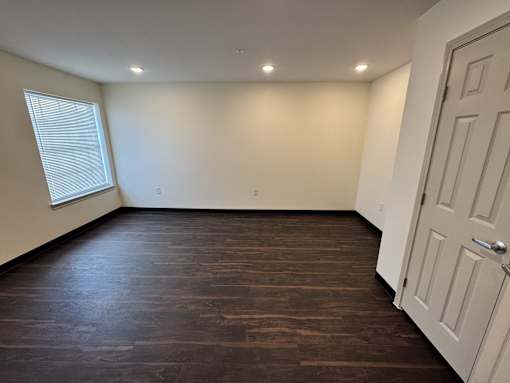 A room with a white door and a window with blinds.