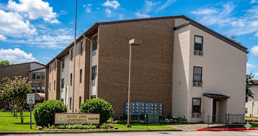 A large brick building with a sign that says Bateman Apartments.
