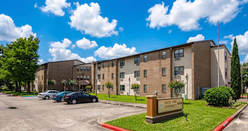 A large Senior Apartment building with a sign that says Baten Arms Apartments.