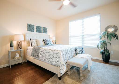 A bedroom with a large bed and a bench in front of it.