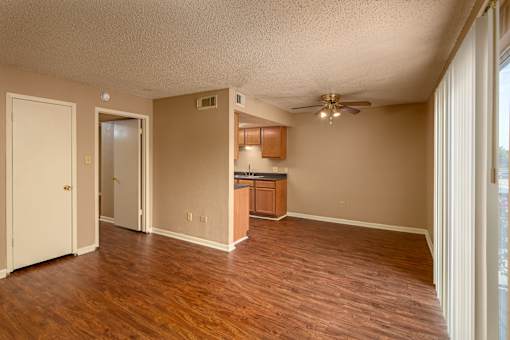 A room with wooden floors and a ceiling fan.