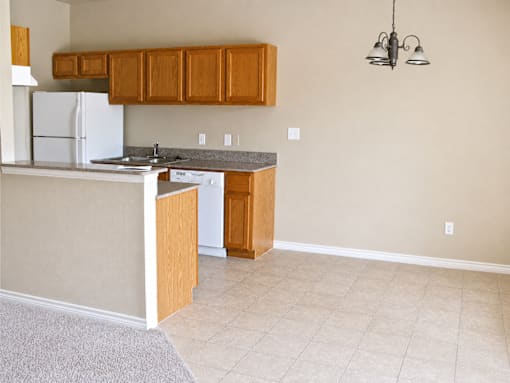 A kitchen with white appliances and wooden cabinets.