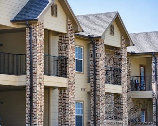 A row of houses with balconies and brick pillars.