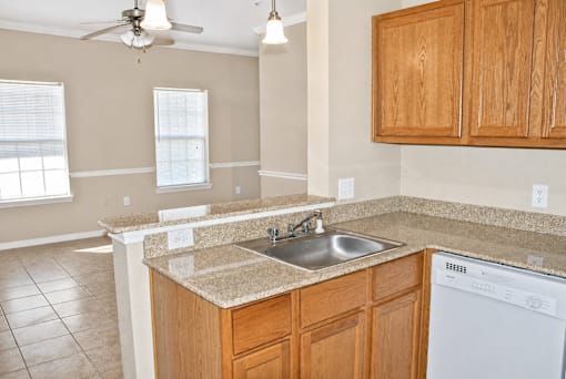 A kitchen with wooden cabinets and a white dishwasher.