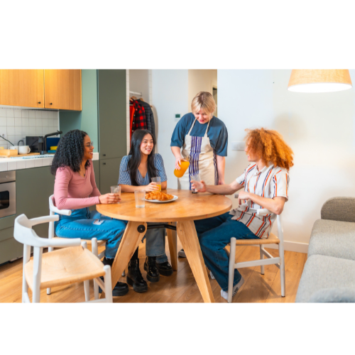 Four people are sitting around a table eating food.