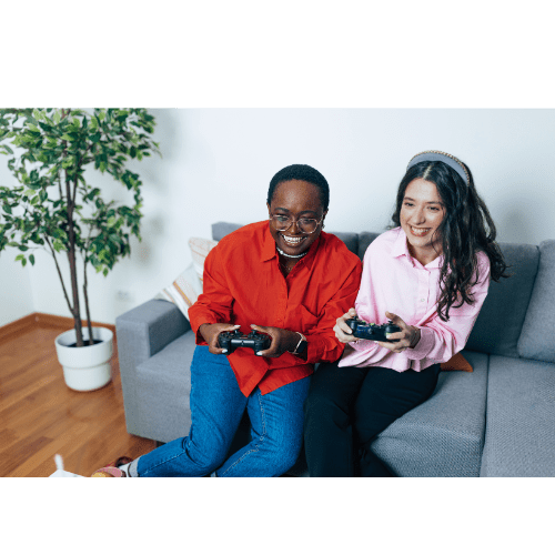 A man and a woman are sitting on a couch, each holding a camera.