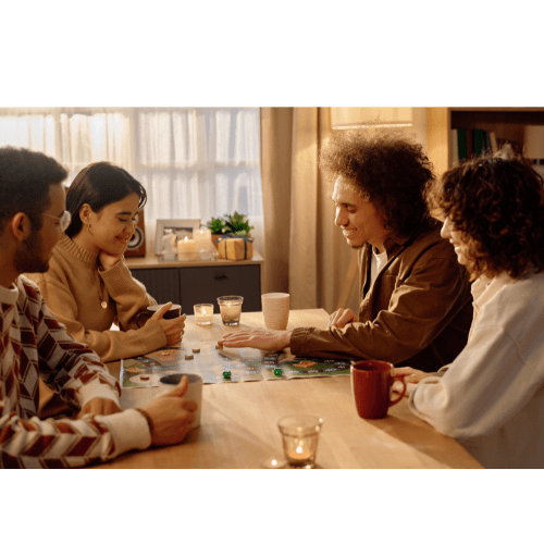 Four people sitting around a table playing a board game.