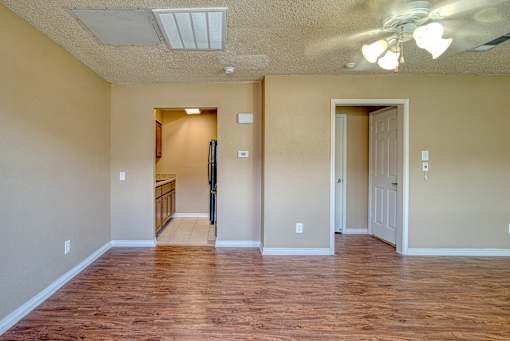 A room with wooden floors and a ceiling fan.