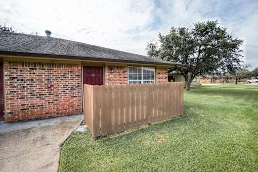 A house with a red door and a brown fence.